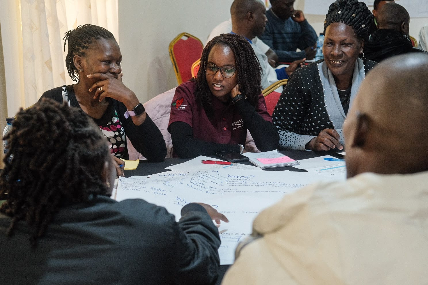 Community members in Kenya discussing sustainability and forest management during a workshop in the Mau Forest region