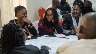 Community members in Kenya discussing sustainability and forest management during a workshop in the Mau Forest region